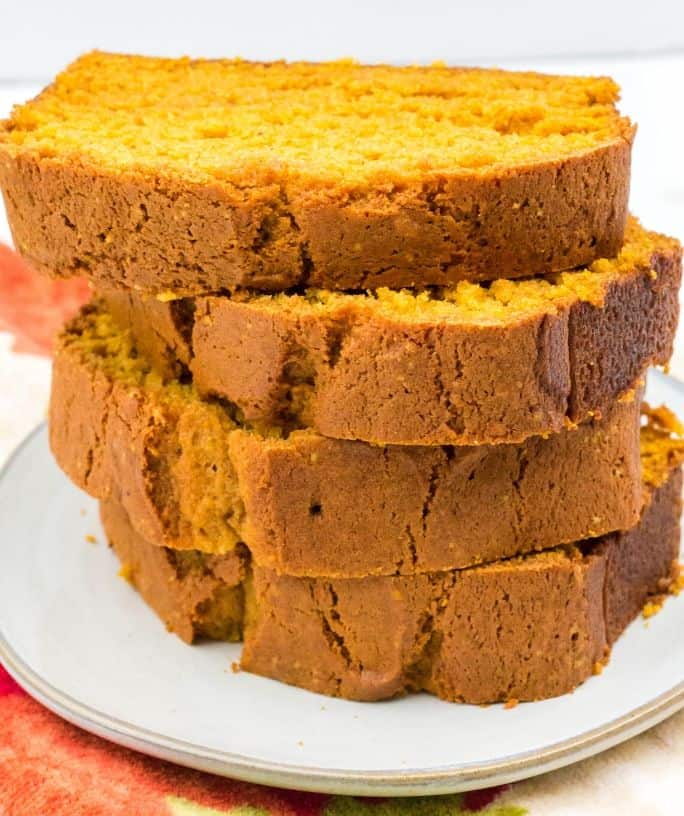 four slices of pumpkin bread stacked up on a white plate