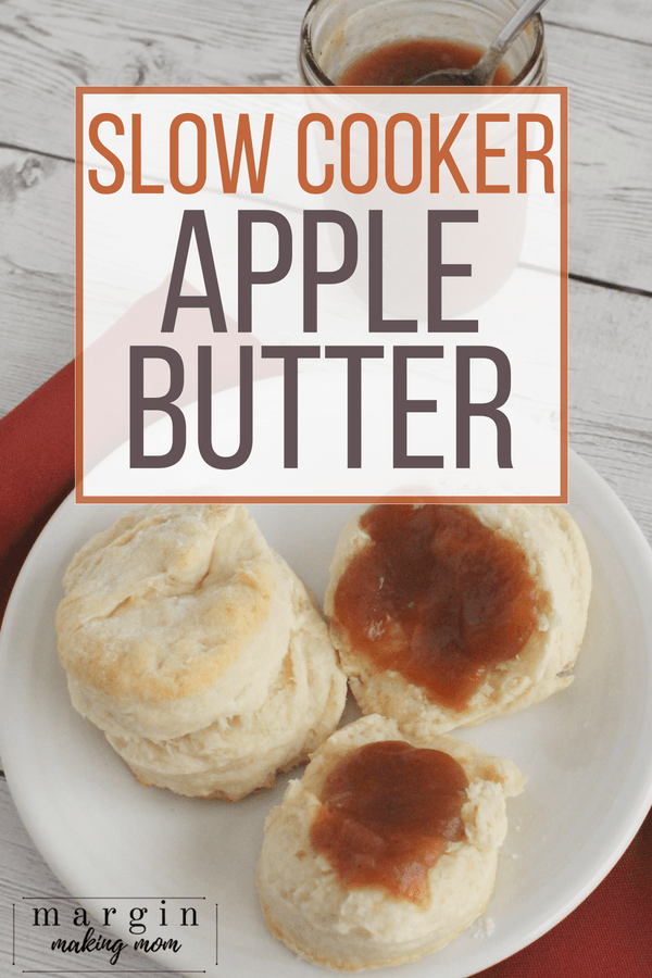 homemade biscuits topped with slow cooker apple butter, resting on a white plate