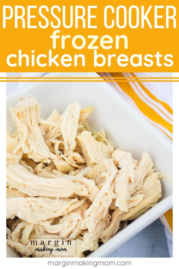 a white bowl of freshly cooked chicken, showing how to make frozen chicken breasts in the Instant Pot pressure cooker