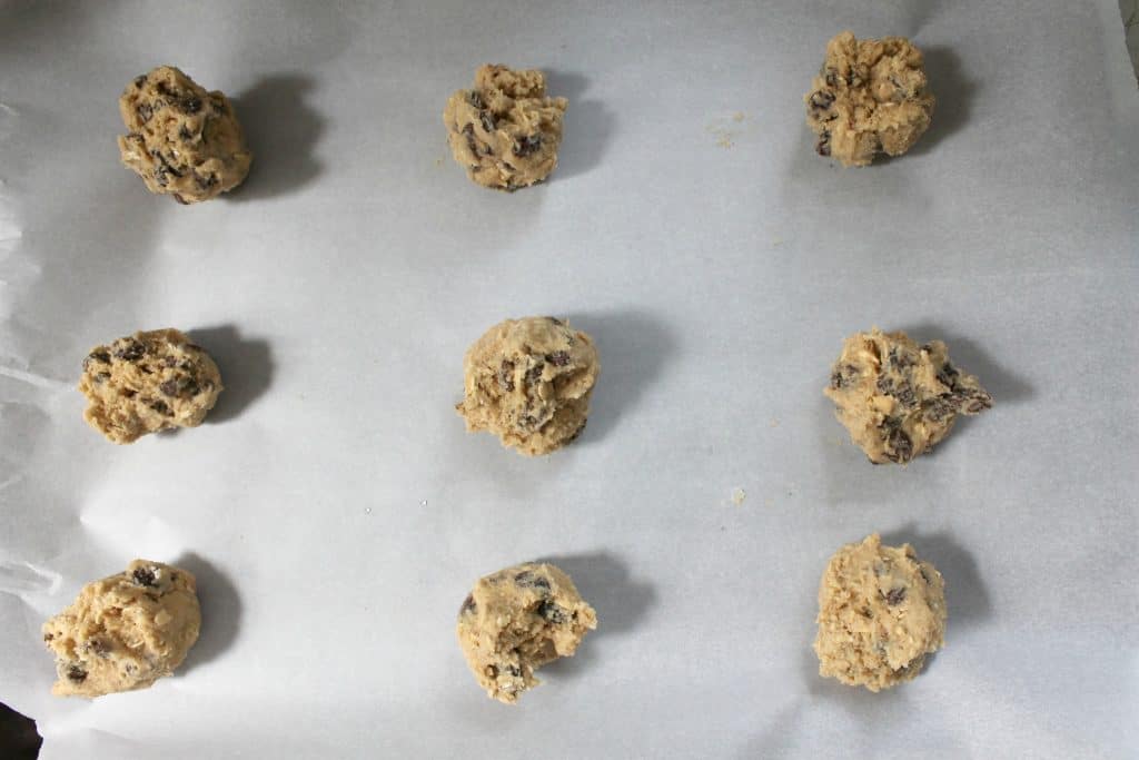 several rounds of oatmeal raisin cookie dough on a baking sheet