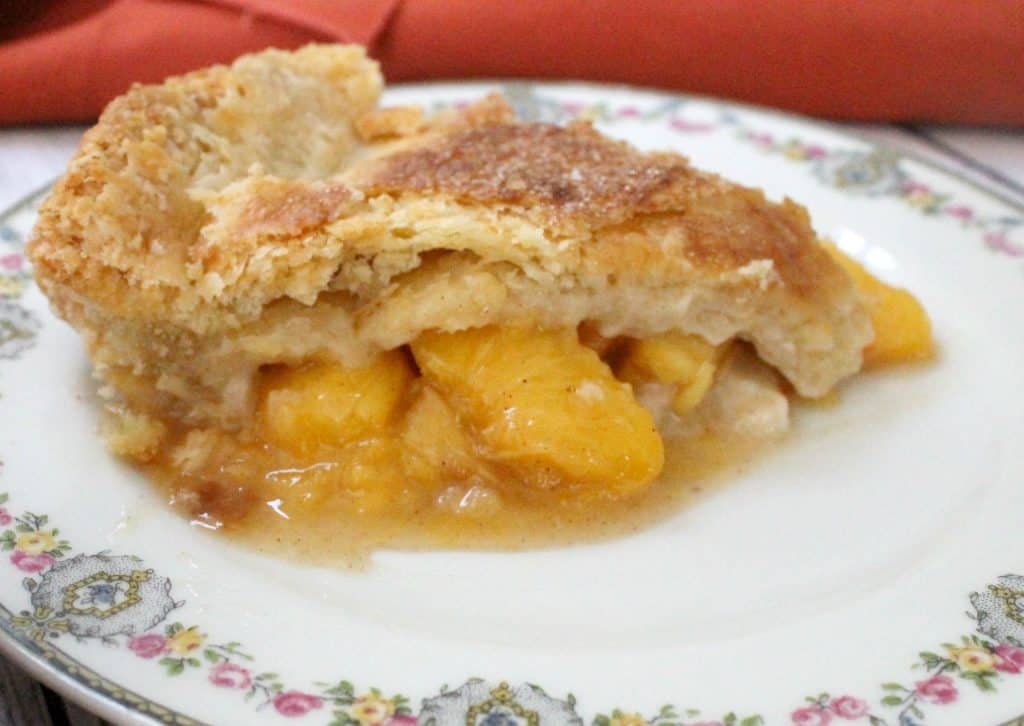 This deep dish peach pie showcases the natural sweetness of perfectly ripe, delicately spiced juicy peaches wrapped in a tender, flaky crust.