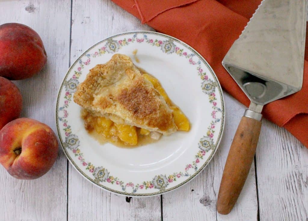 This deep dish peach pie showcases the natural sweetness of perfectly ripe, delicately spiced juicy peaches wrapped in a tender, flaky crust.