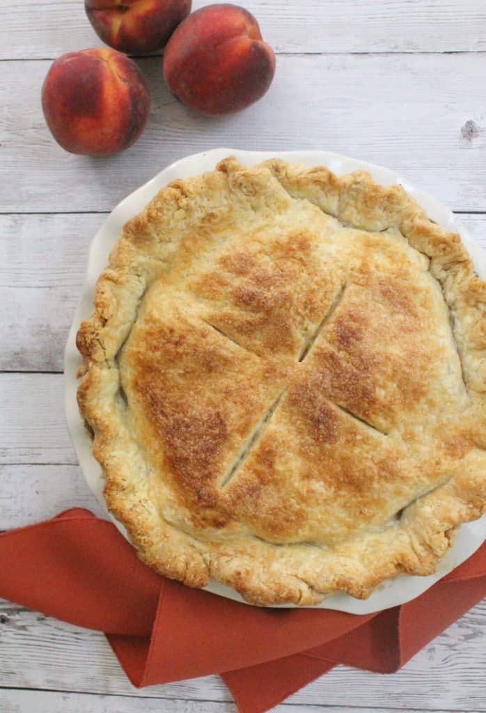 This deep dish peach pie showcases the natural sweetness of perfectly ripe, delicately spiced juicy peaches wrapped in a tender, flaky crust.