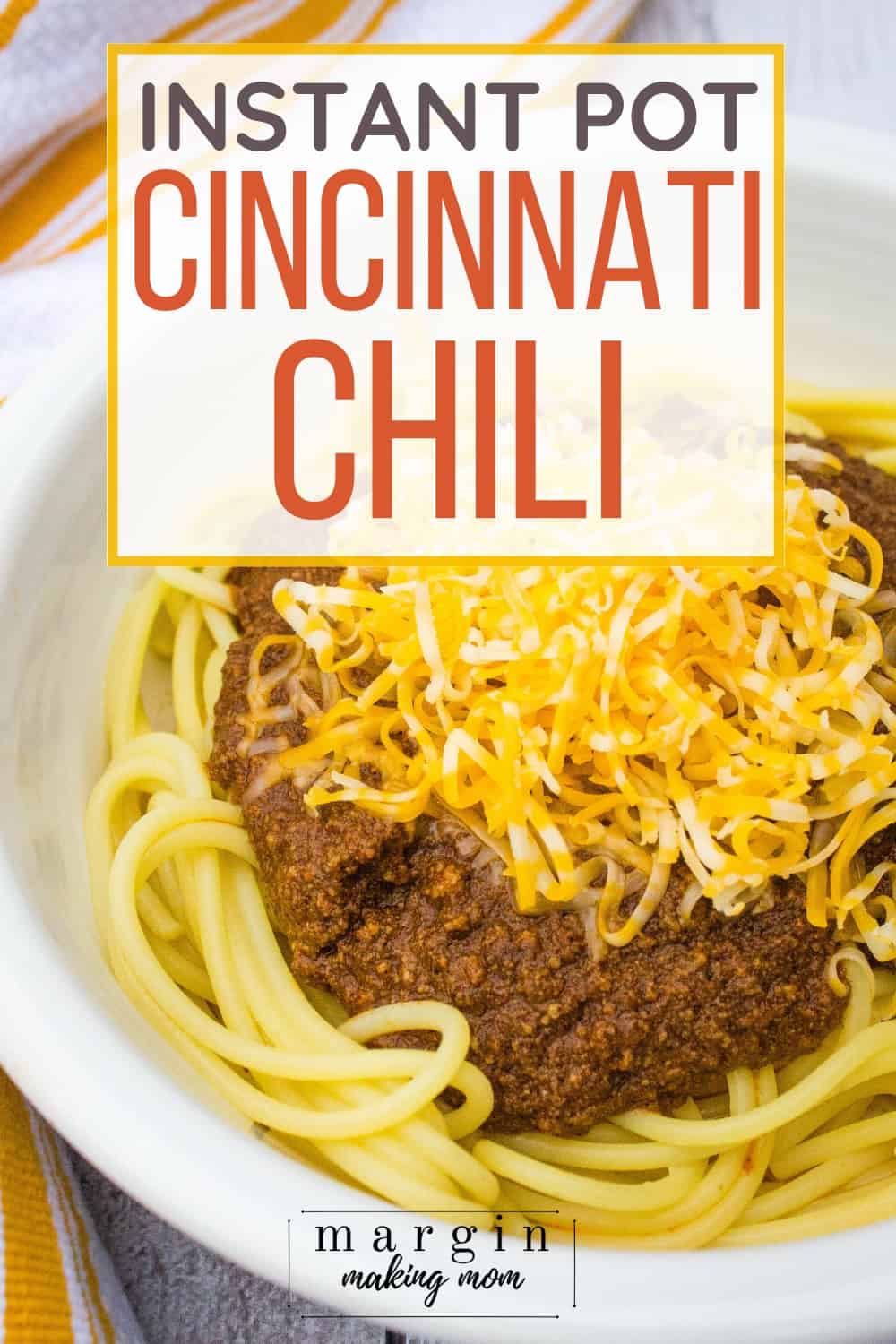 white bowl filled with spaghetti topped with Instant Pot Cincinnati Chili and shredded cheese