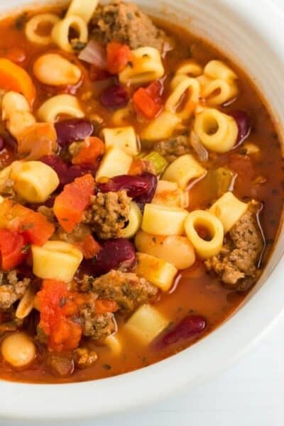 close-up view of a white bowl filled with Instant Pot pasta e fagioli soup, a copycat Olive Garden recipe