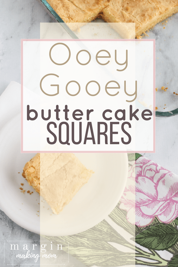 piece of ooey gooey butter cake on a small white plate, set on a pink floral napkin, with the baking dish in the background