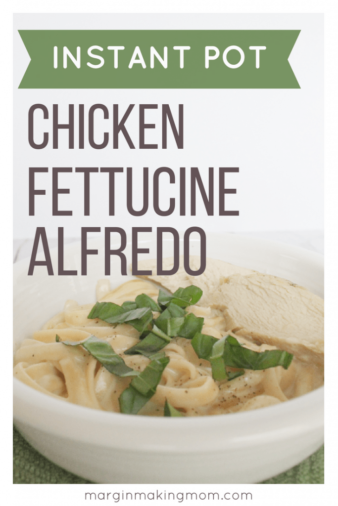 white bowl filled with pressure cooker chicken fettucine alfredo and topped with fresh basil