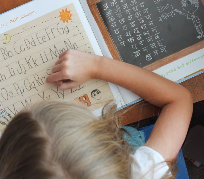 Girl reading a book about the alphabets in different cultures