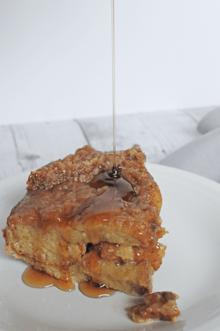 syrup being drizzled ona piece of pressure cooker french toast on a white plate