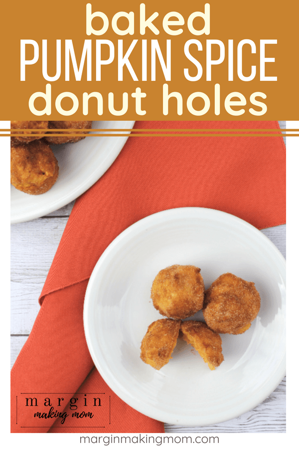 pumpkin donuts on a white plate next to an orange cloth napkin