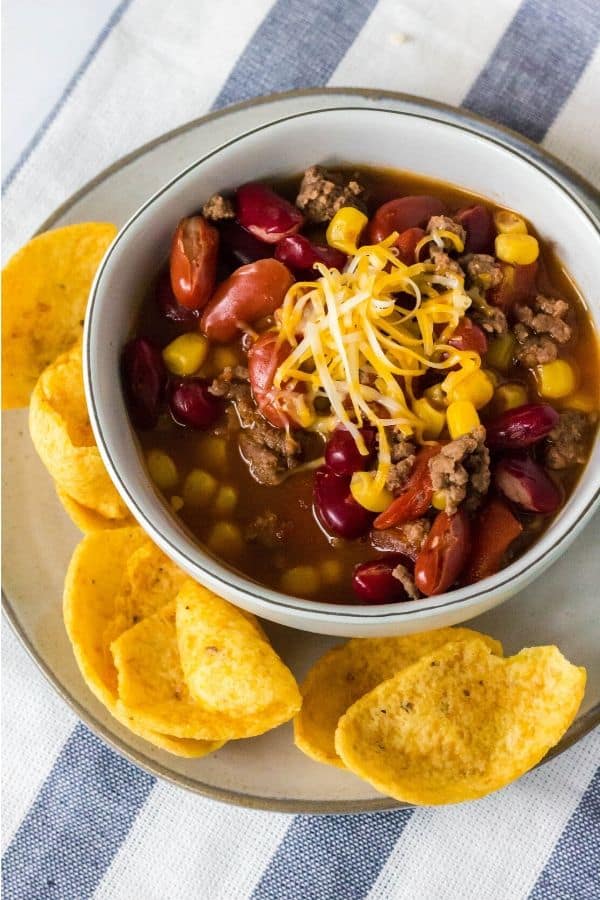 taco soup in a white bowl next to Fritos corn chips