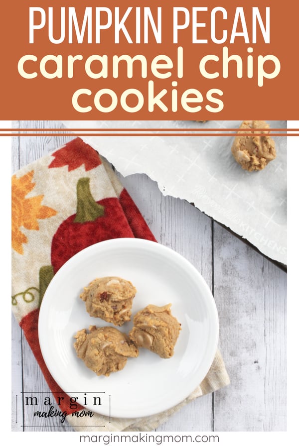 white plate with pumpkin pecan caramel chip cookies, resting on a pumpkin printed hand towel