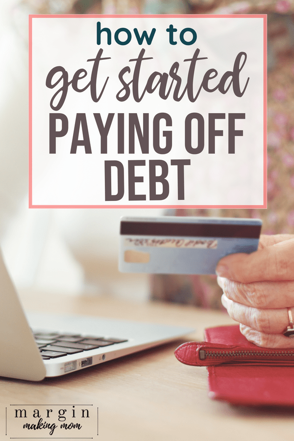 woman's hand holding a credit card while looking at a laptop