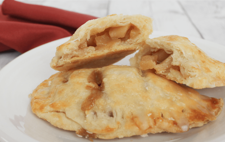 apple hand pies with filling exposed, resting on a white plate