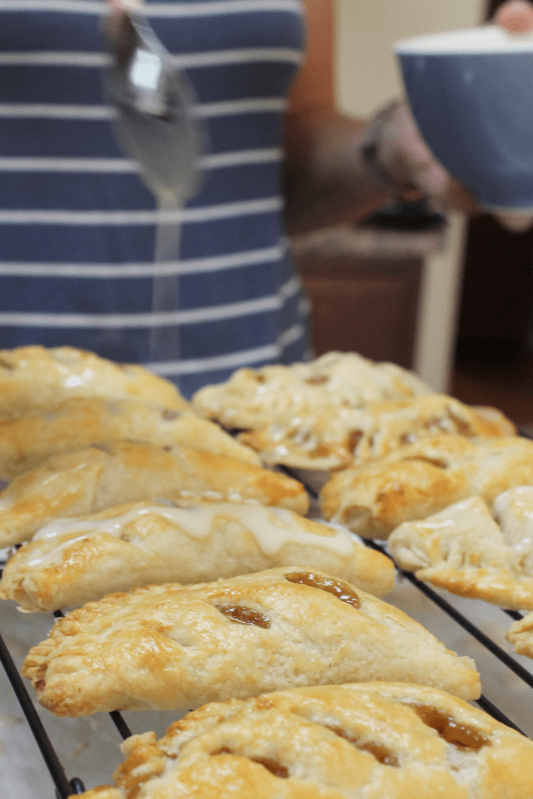 easy apple hand pies on a cooling rack, being drizzled with glaze