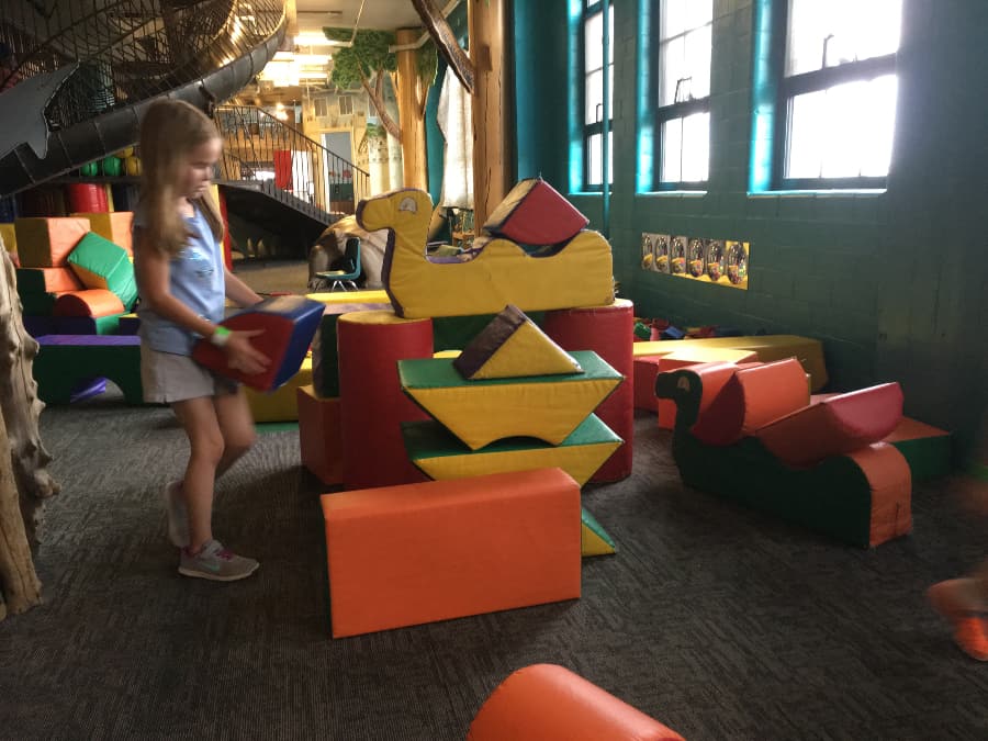 girl building a block tower in the St. Louis City Museum