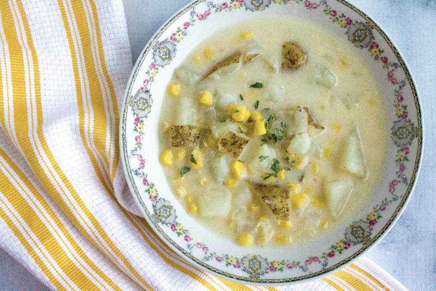 china bowl filled with instant pot corn chowder with potatoes