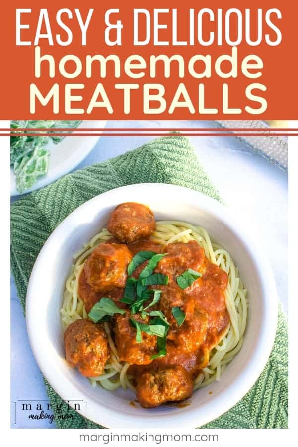 white bowl of spaghetti and homemade meatballs with sauce, on a green hand towel