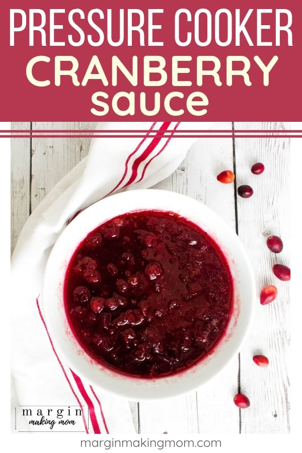 white bowl of instant pot cranberry sauce, next to some scattered fresh cranberries and a white and red kitchen towel