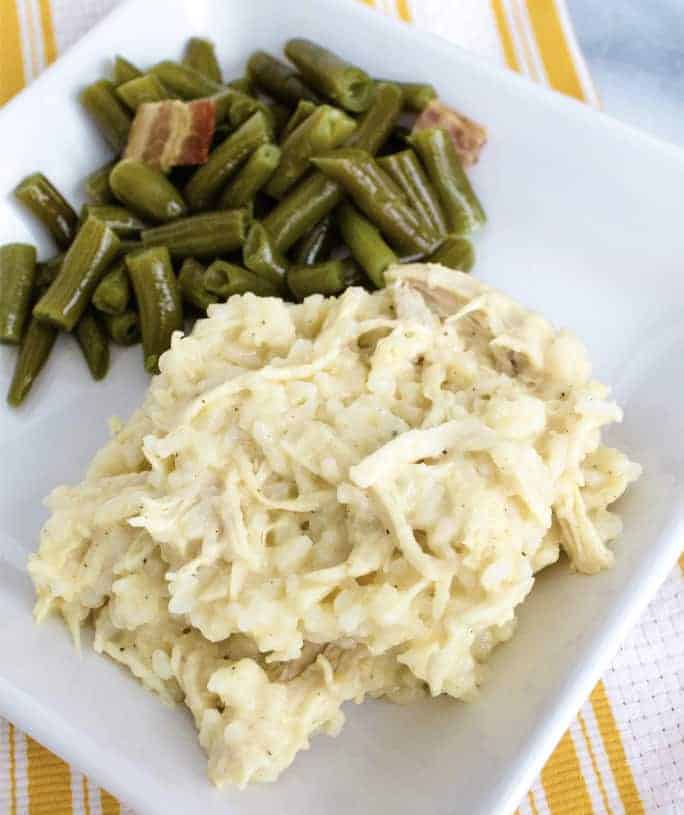 white plate with Instant Pot chicken and rice casserole on it, alongside green beans