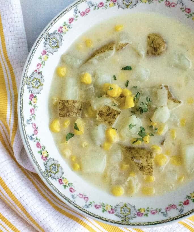 china bowl filled with instant pot corn chowder with potatoes