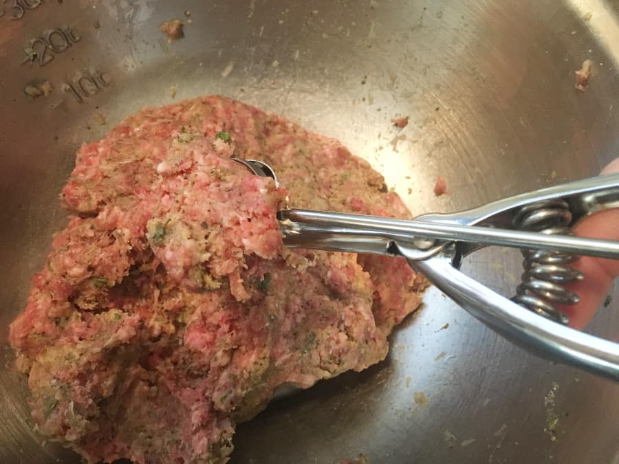 stainless steel bowl sith meatball mix and a cookie scoop