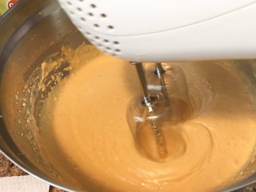 white electric mixer mixing filling for frozen pumpkin cheesecake