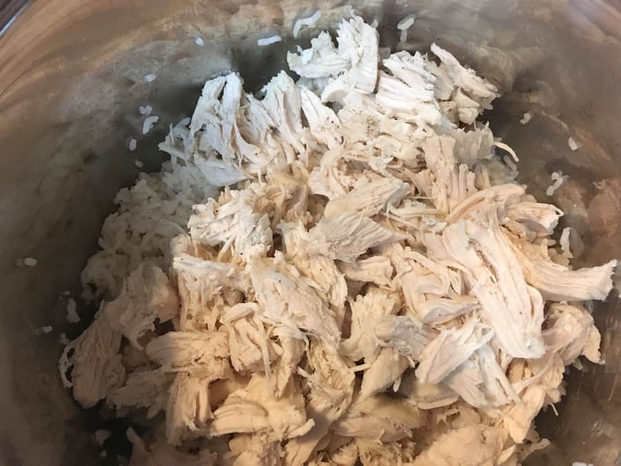 shredded cooked chicken over cooked rice in an instant pot