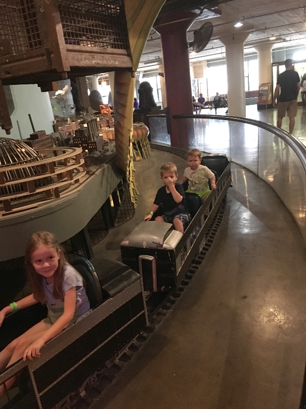 three kids riding the train inside the City Museum in St. Louis