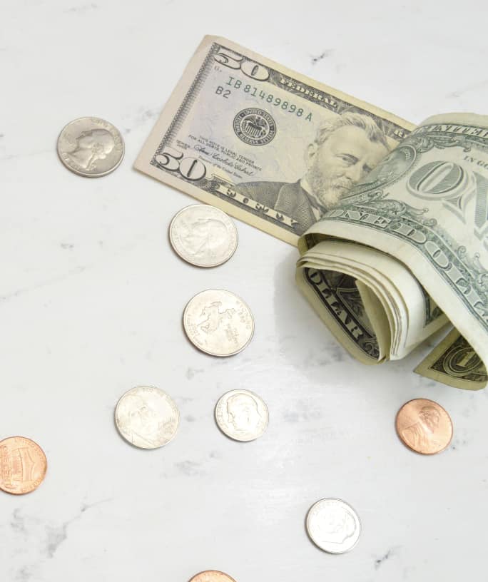 folded dollar bills with coins