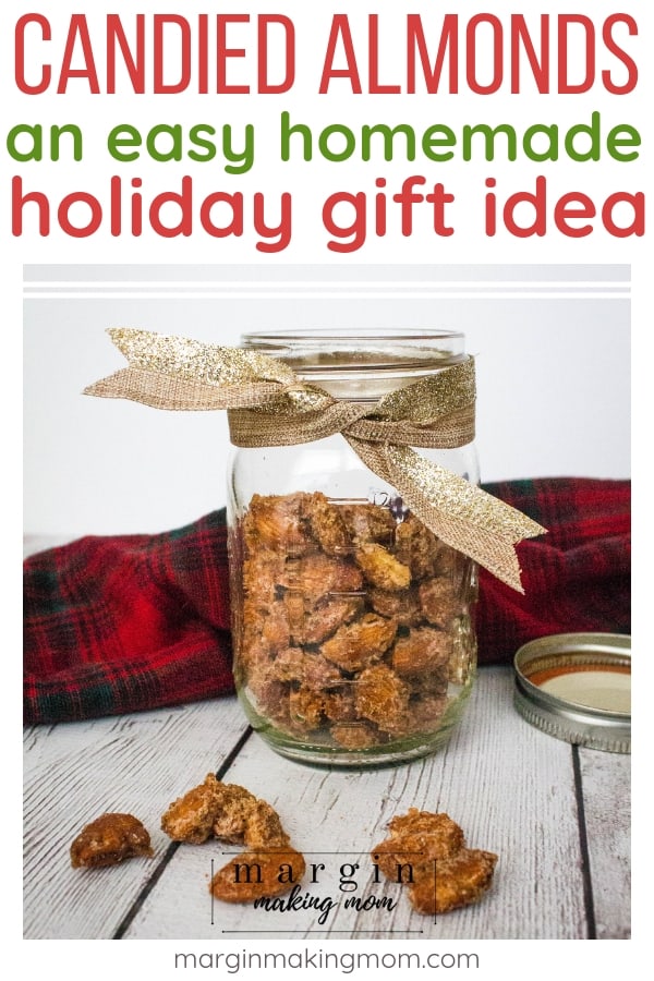 jar of candied almonds wrapped with a gold sparkle bow in front of a red plaid fabric