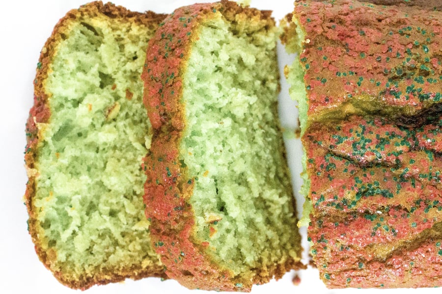 sliced loaf of pistachio bread with red and green sprinkles for christmas