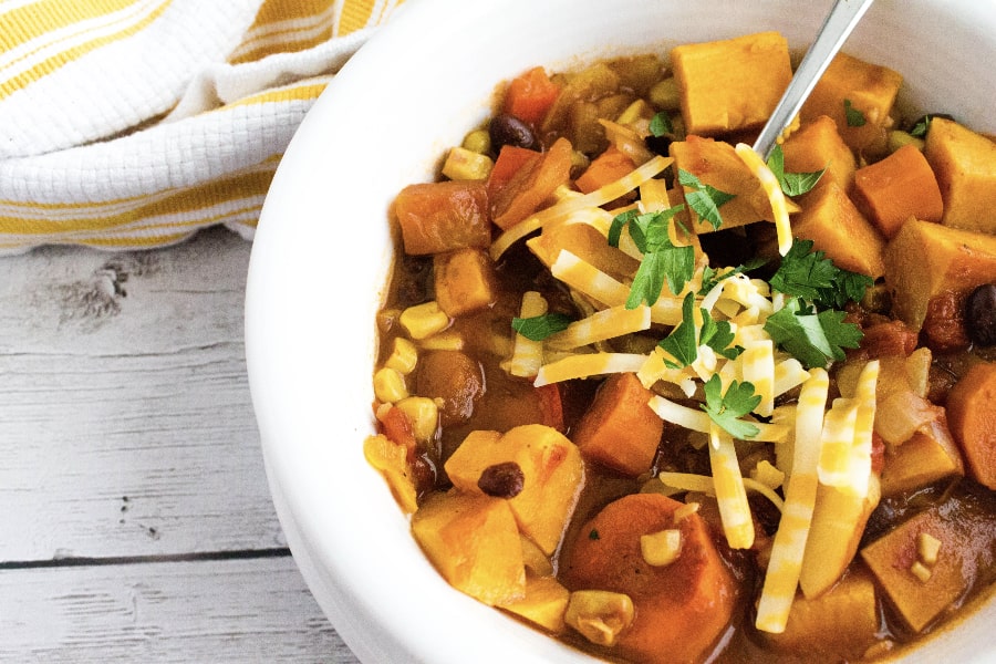 meatless vegetarian sweet potato chili made in the Instant Pot, served in a white bowl and topped with cheese