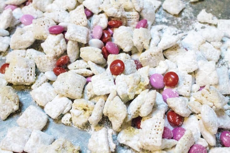 valentine's snack mix for goodie bags made from chex cereal, white chocolate, peanut butter, butter, powdered sugar, and m&m's.