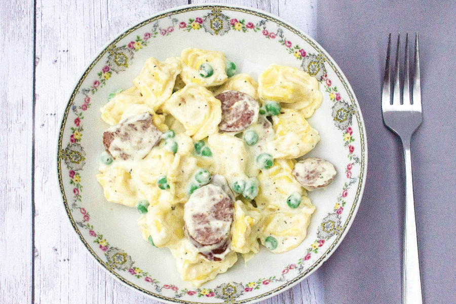 bowl filled with creamy tortellini and sausage cooked in the Instant Pot pressure cooker