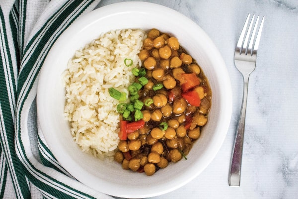 white bowl filled with white rice and kung pao chickpeas made in the Instant Pot