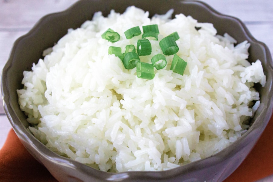 Instant Pot jasmine rice in a brown bowl, topped with sliced green onions