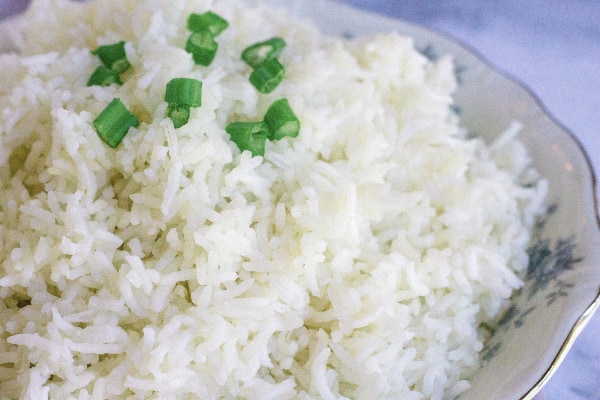 china bowl filled with Instant Pot basmati rice and topped with sliced green onions