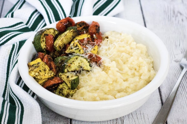 white bowl filled with instant pot parmesan risotto and roasted vegetables