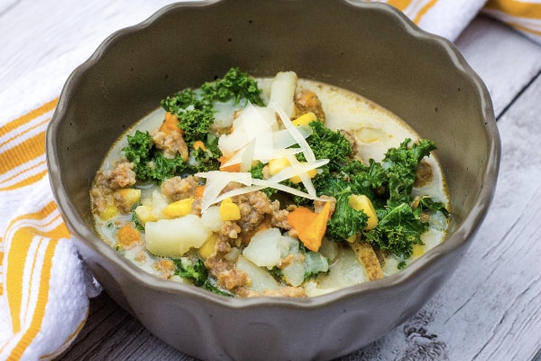 brown bowl filled with instant pot corn, sausage, and potato chowder
