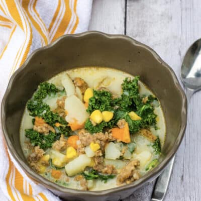 brown bowl filled with potato, corn, sausage chowder made in the Instant Pot