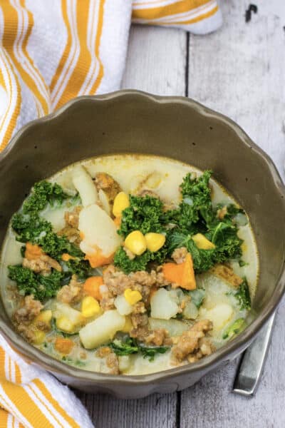 brown bowl filled with potato, corn, sausage chowder made in the Instant Pot