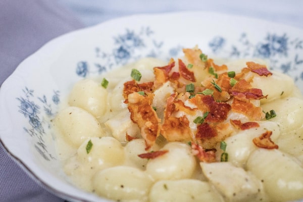 blue floral china bowl filled with pressure cooker bacon chicken ranch gnocchi