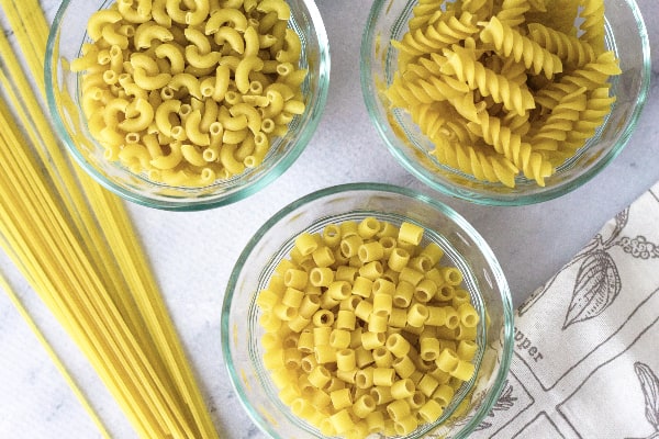 three glass bowls filled with dry pasta, as examples of the types you can cook in the Instant Pot