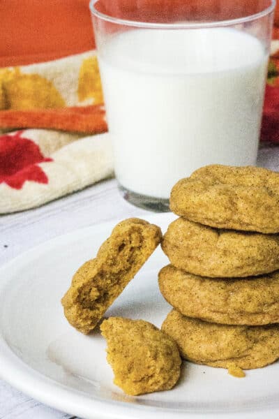 white plate with pumpkin snickerdoodles on it, next to a glass of milk