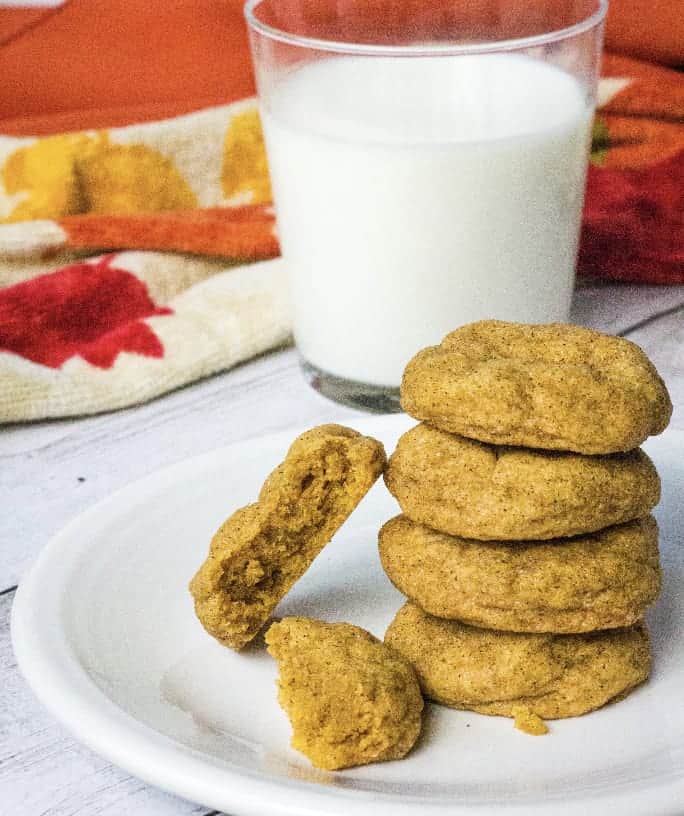 white plate with pumpkin snickerdoodles on it, next to a glass of milk