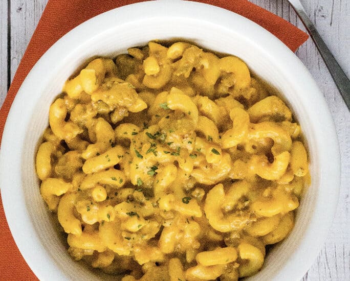 white bowl filled with Instant Pot pumpkin macaroni and cheese with sausage