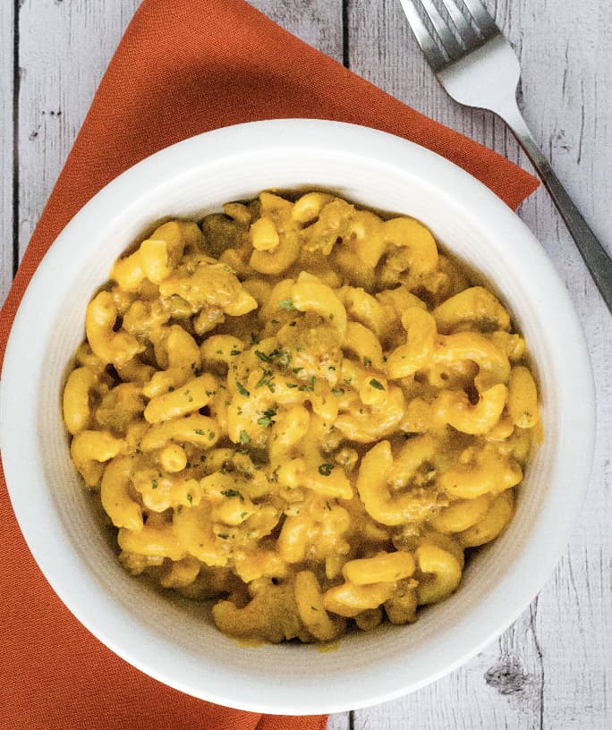white bowl filled with Instant Pot pumpkin macaroni and cheese with sausage