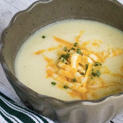 brown bowl filled with cheesy cauliflower soup cooked in the Instant Pot