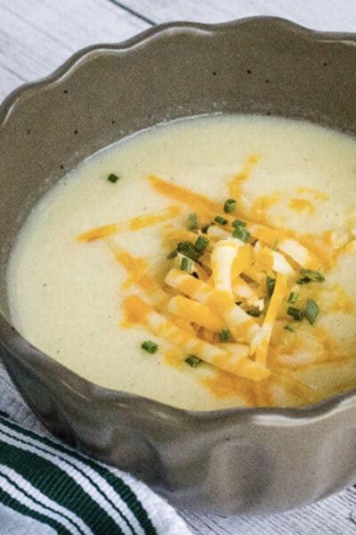 brown bowl filled with cheesy cauliflower soup cooked in the Instant Pot